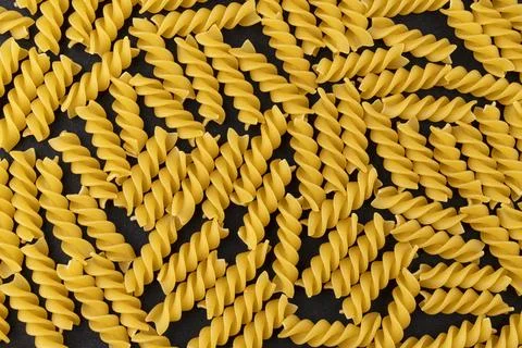 Fusilli pattern on black background, top view, flat lay texture Stock Photos