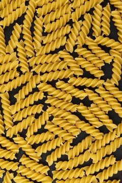 Fusilli pattern on black background, top view, flat lay texture Stock Photos