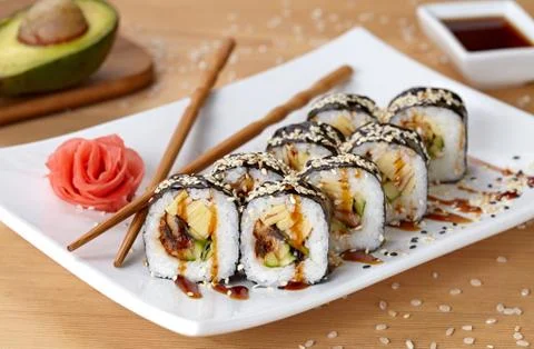 Futomaki sushi roll with eel, cucumber, sesame seeds, ginger, and soy sauce Stock Photos