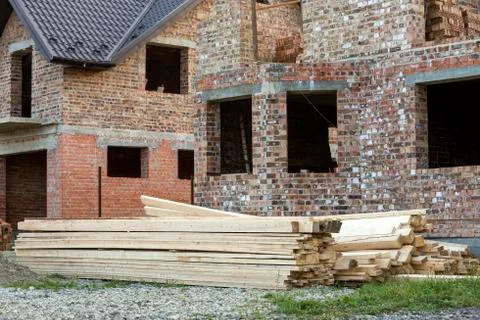 Future cottage under construction and pile of gravel and stack of boards in f Stock Photos