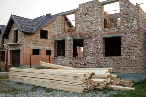 Future cottage under construction and pile of gravel and stack of boards in f Stock Photos