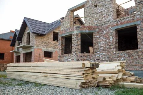 Future cottage under construction and pile of gravel and stack of boards in f Stockfoto's