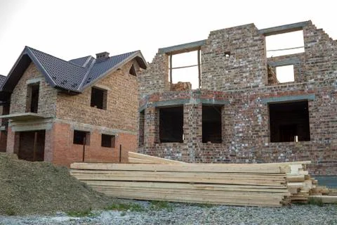 Future cottage under construction and pile of gravel and stack of boards in f Stock Photos