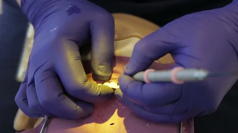 Future Dentist Placing a Front Tooth Filling on a Manikin Stock Footage 100568495