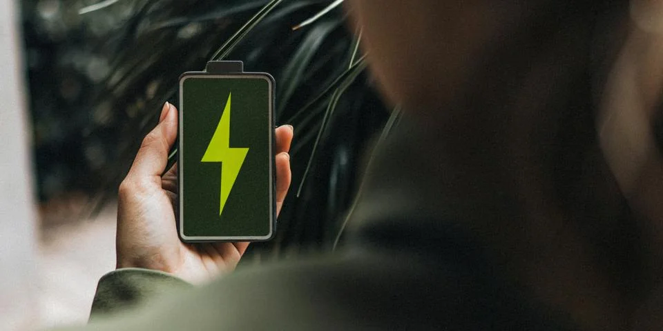 Future fast charging technology featuring a hand holding a green battery symbol Stock Photos
