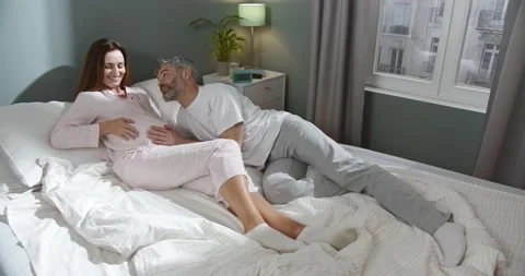 Future father. High angle view of the happy bearded man putting his head at the Stock Footage 156460440