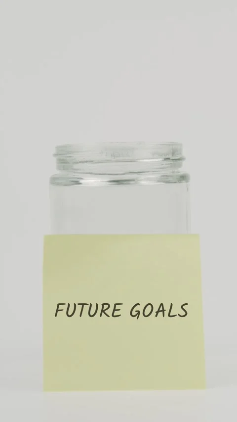 Future goals text or word on yellow sticky note attached to glass jar Stock Footage 311737485