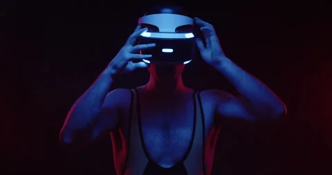 Future handsome man in tracksuit puts on VR glasses helmet and prepares to dive Stock Footage 157390304