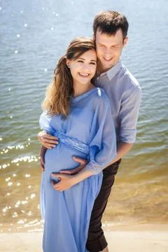 Future mom and dad hugging in nature Stock Photos