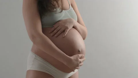Future mother gently strokes her belly with baby inside, waiting for childbirth Stock Footage 220846349