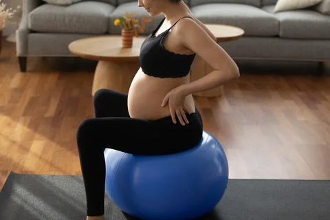 Future mum in sportswear practice gymnastics for pregnant on fitball Stock Photos