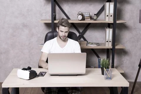 Future is now. Handsome man work on laptop at home. Guy explore VR computer 스톡 사진