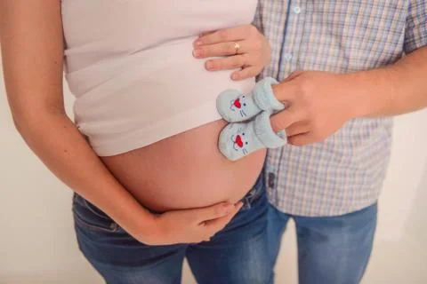 Future parents keep booties on the belly Stock Photos