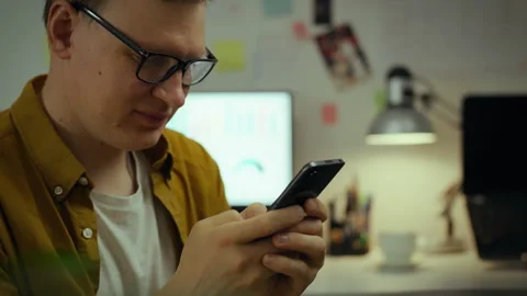 A future techie takes a break from classes, using a mobile gadget in dorm ro Stock Footage 285187032