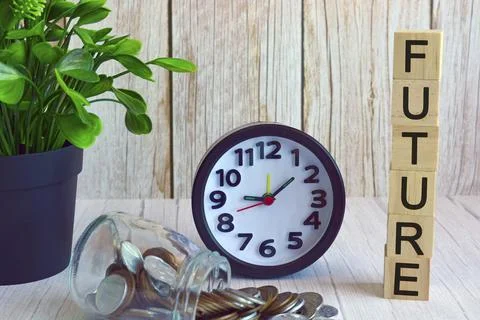 Future text on wooden block cube with alarm clock, potted plant and coins Stock Photos