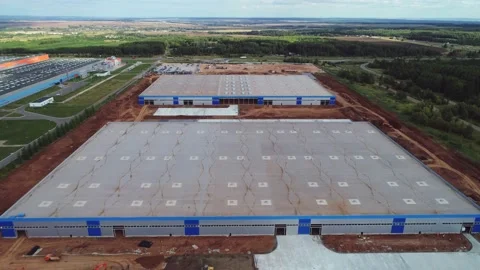 Future warehouses with flat roofs among green fields arial Stock Footage 139492899