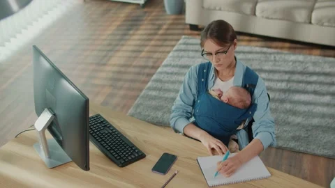 Future Of Work New Work Culture. Mother Works On Computer While Holding Baby At Stock Footage 318361474