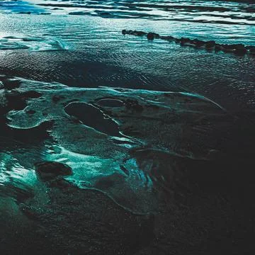 Futuristic Abstract Texture of Dark Sand and Water with Turquoise Highlights Foto stock