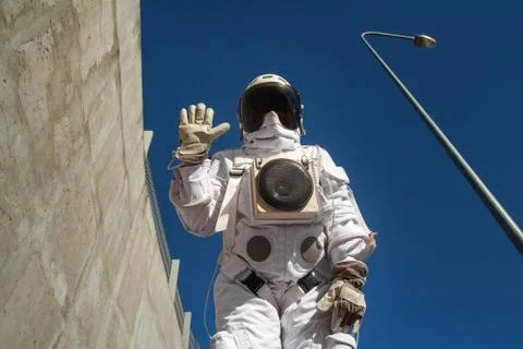 Futuristic astronaut in a helmet against gray walls. Fantastic Cosmic Costume Stock Photos
