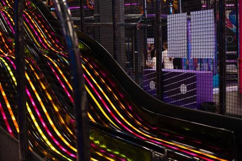 Futuristic dynamic slide with neon led lighting in modern children's entertai Stock Photos