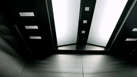 Futuristic elevator interior with geometric ceiling lights and brushed meta.. Fotos Stock