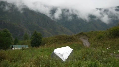 Futuristic geometric silver tent in misty mountains green field landscape Stock Footage 315901889