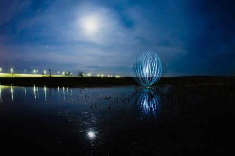 Futuristic glowing sphere reflected on the river surface Stock Photos