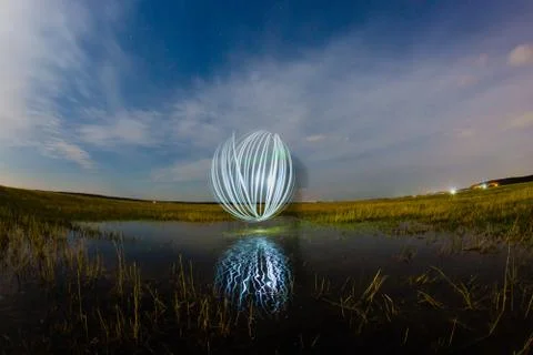 Futuristic glowing sphere reflected on the river surface Foto stock
