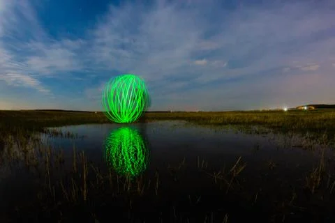 Futuristic glowing sphere reflected on the river surface Stock Photos