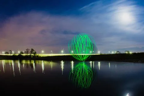 Futuristic glowing sphere reflected on the river surface Stock Photos