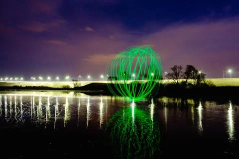 Futuristic glowing sphere reflected on the river surface Stock Photos