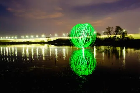 Futuristic glowing sphere reflected on the river surface Stock Photos