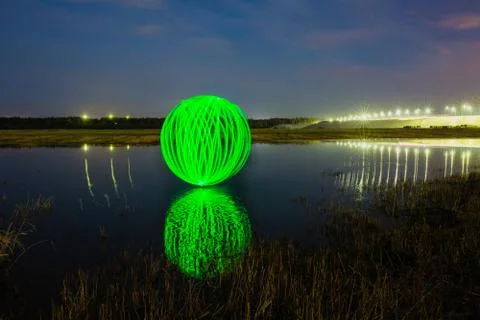 Futuristic glowing sphere reflected on the river surface Stock Photos
