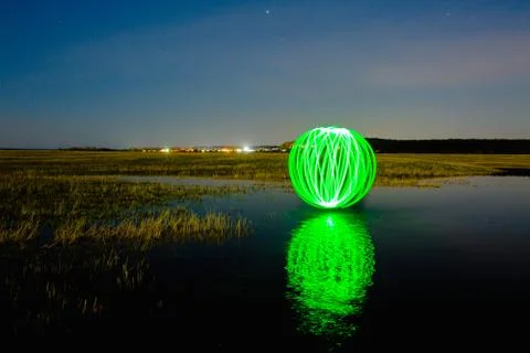 Futuristic glowing sphere reflected on the river surface Stock Photos