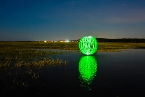 Futuristic glowing sphere reflected on the river surface Stock Photos
