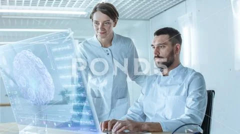 In the Futuristic Laboratory Male and Female Scientists Talk While Working Stock Photos