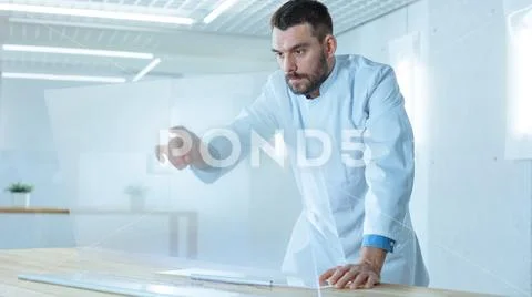In the Futuristic Laboratory Male Scientist Works on His Transparent Computer Stock Photos