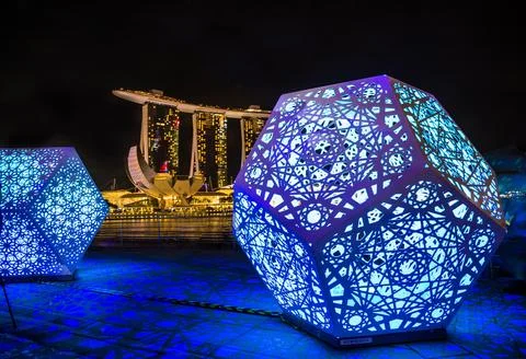 Futuristic light structures illuminate a modern city skyline with the iconic Stock Photos