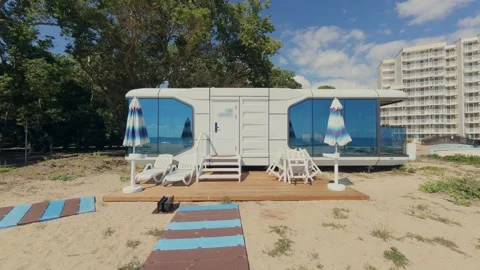 Futuristic Modern Capsule House on Sandy Beach Near the Sea Horizon Stock Footage 346691470