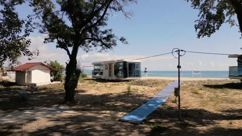 Futuristic Modern Capsule House on Sandy Beach Near the Sea Horizon Stock Footage 346699696