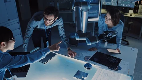 Futuristic Robotic Arm Picking Up a Metal Object and Moving It. Senior Engineer Stock Footage 105346448