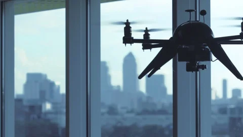 Futuristic sci-fi drone flies inside in front of window with London view Stock Footage 106396490
