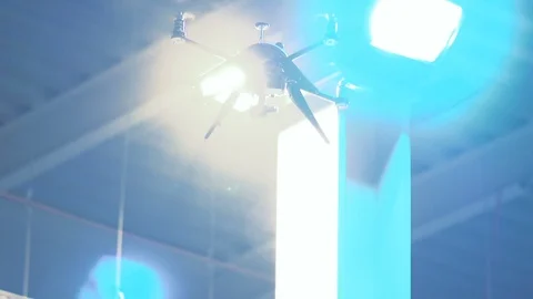 Futuristic sci-fi drone hovers in front of bright industrial lights Stock Footage 106711685
