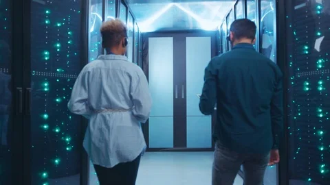 In futuristic server room multi-ethnic female and male IT specialists discussing Video stock 119842916