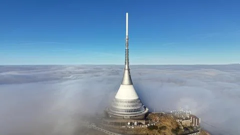 Futuristic Tower Peaks Above Clouds, Dawn Illuminates Tower Perched On Moun.. Stock Photos
