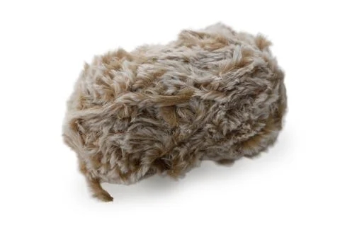Fuzzy brown object resembling a playful creature resting on a soft surface 库存照片