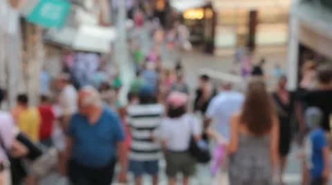 Fuzzy view of shoppers walking up and down hill (HD) c Stock Footage 11585668