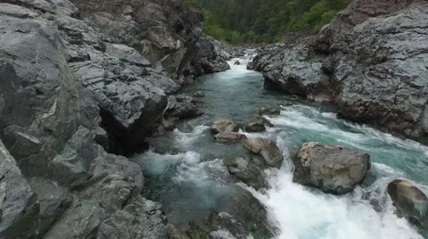 Fying low over the water running through a rocky canyon Stock Footage 53301310