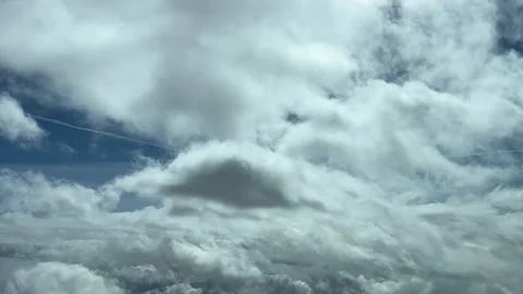 Fying through some tiny clouds in a deep blue sky. Pilot point of view. Stock Footage 235712497