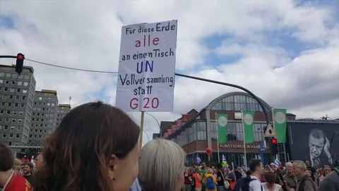 G20 demonstration Hamburg, big demonstrator crowd, sign for UN general assembly Vídeos de archivo 77555352